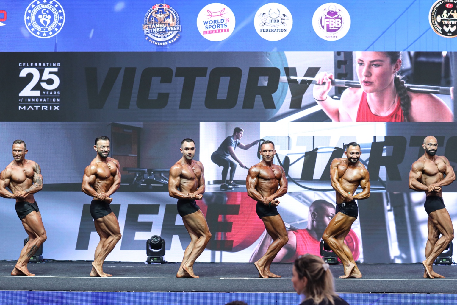 Classic Physique sporcuları sahnede poz verirken